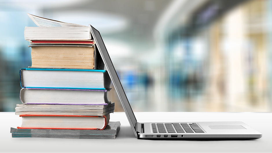 Pile of books and a laptop