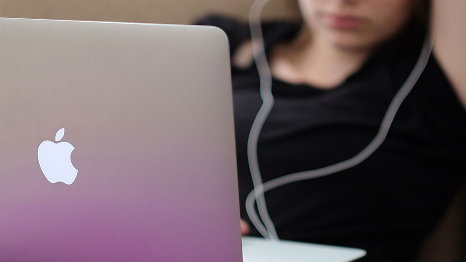 Woman looking at Apple laptop