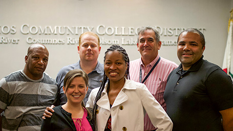 A group of six smiling employees