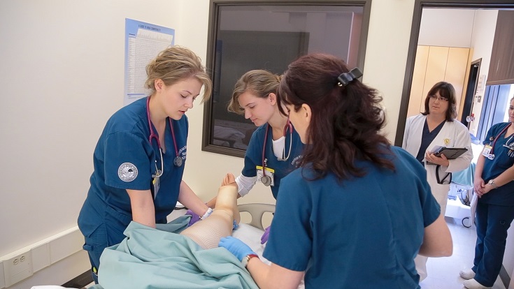 Nursing students gathered around a patient on a gurney