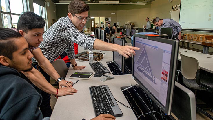 Students looking at an architecture model on a computer