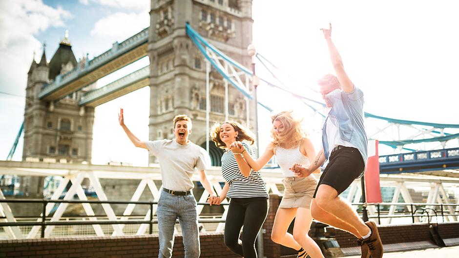 London, England students in front of London Bridge laughing and jumping